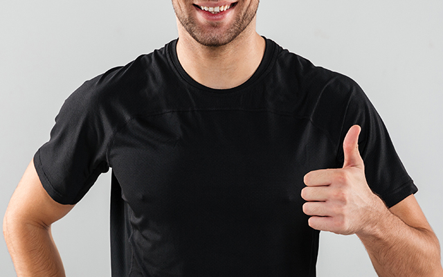 Hombre con camiseta negra levanta el dedo pulgar mientras sonr&iacute;e